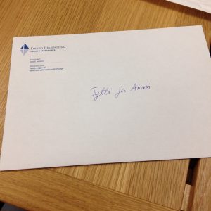 valkoinen seurakunnan logolla varustettu kirjekuori, jossa lukee päällä "Tytti&Anssi"