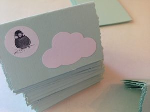 Mintunvihreä paikkakortti, jossa pilven muotoinen valkoinen alue ja pyöreä lintutarra.
